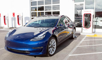 a parked blue tesla model 3 while charging