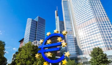 the euro logo and the european central bank headquarters behind it