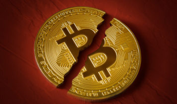 a bitcoin broken in half with a maroon background
